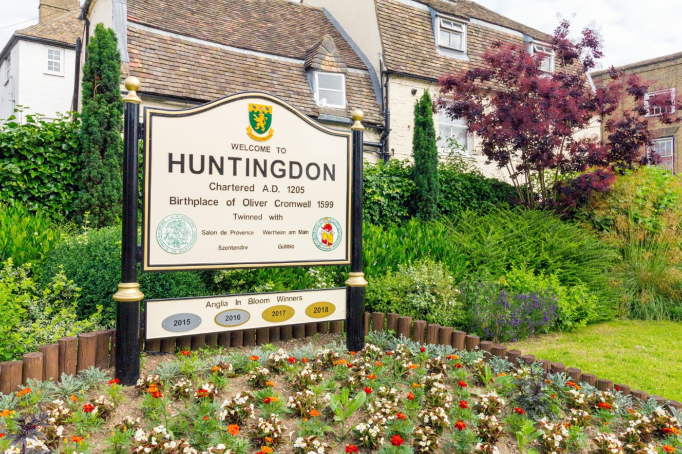 Welcome to Huntingdon town sign with flowering garden border for removals Huntingdon service area